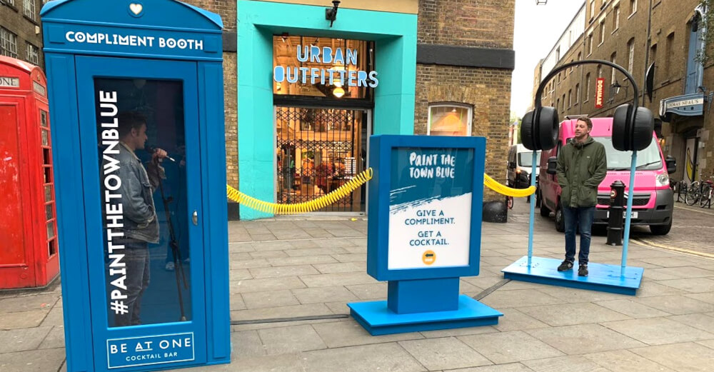 A brand activation with a blue box and giant headphones with printed products