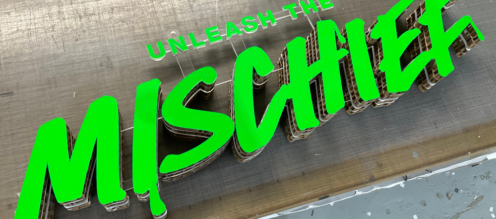 A 3D display board, built to form a bright green logo.