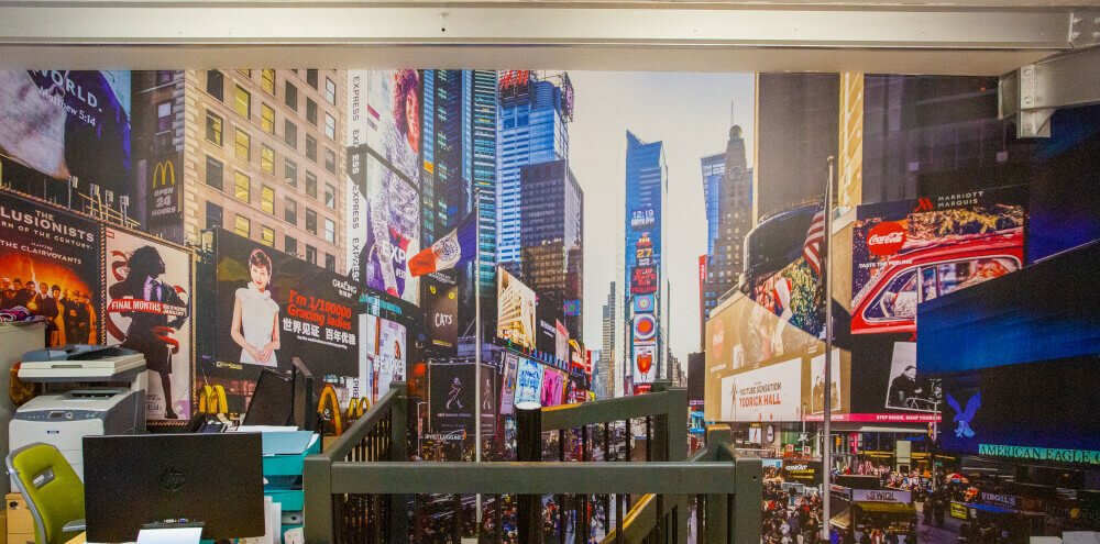 A one-piece section of wall graphics in an office, with a New York landscape